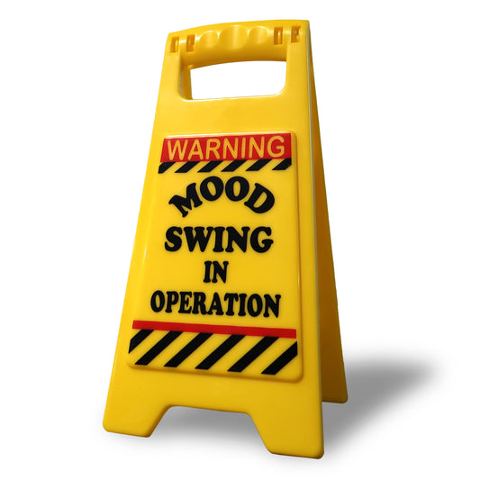 Bright and humorous Mood Swing Warning Sign on a desk, adding a playful vibe to any office space with its bold text.