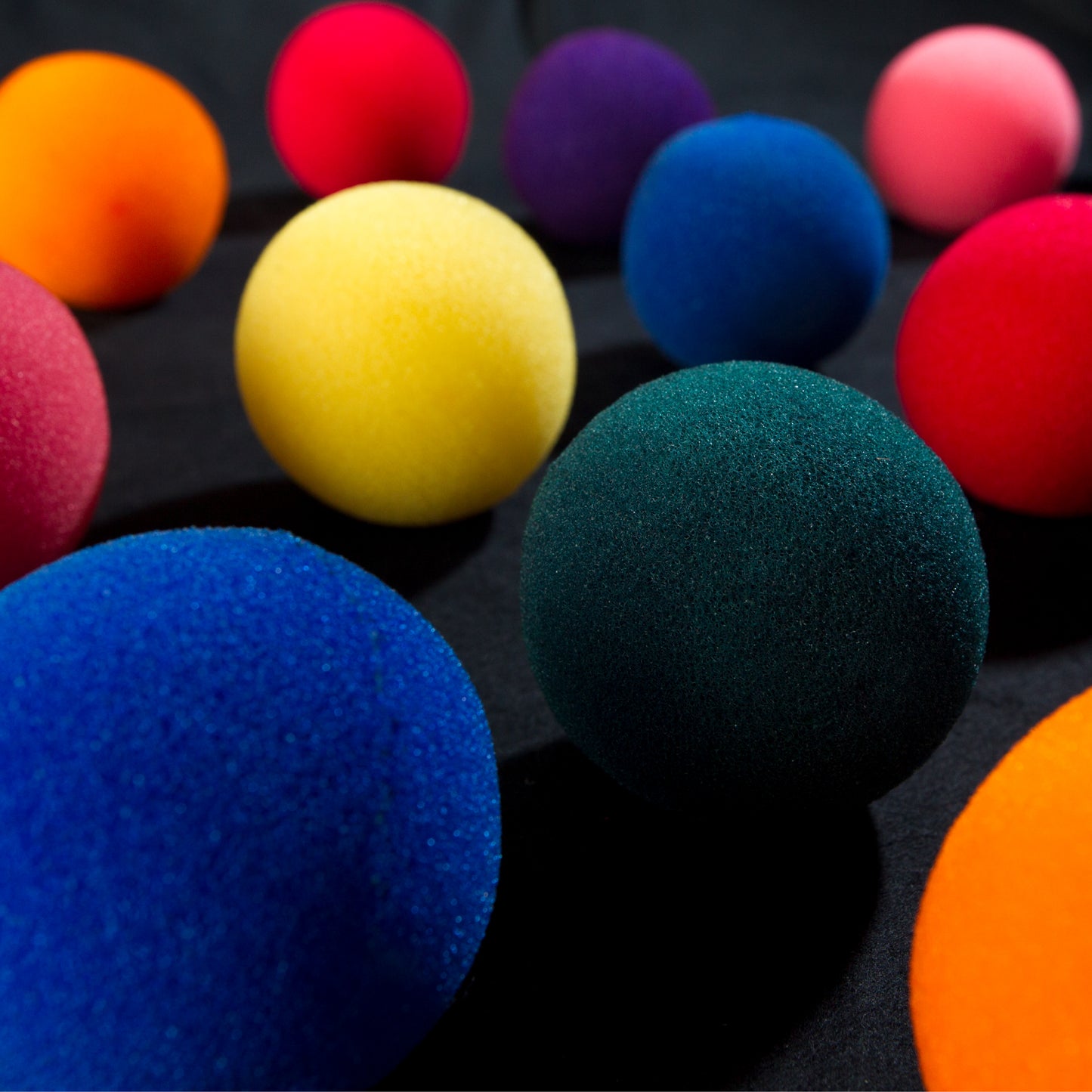 Vibrant set of four 2-inch sponge balls with a soft, squeezable texture, ideal for close-up and stage magic tricks.