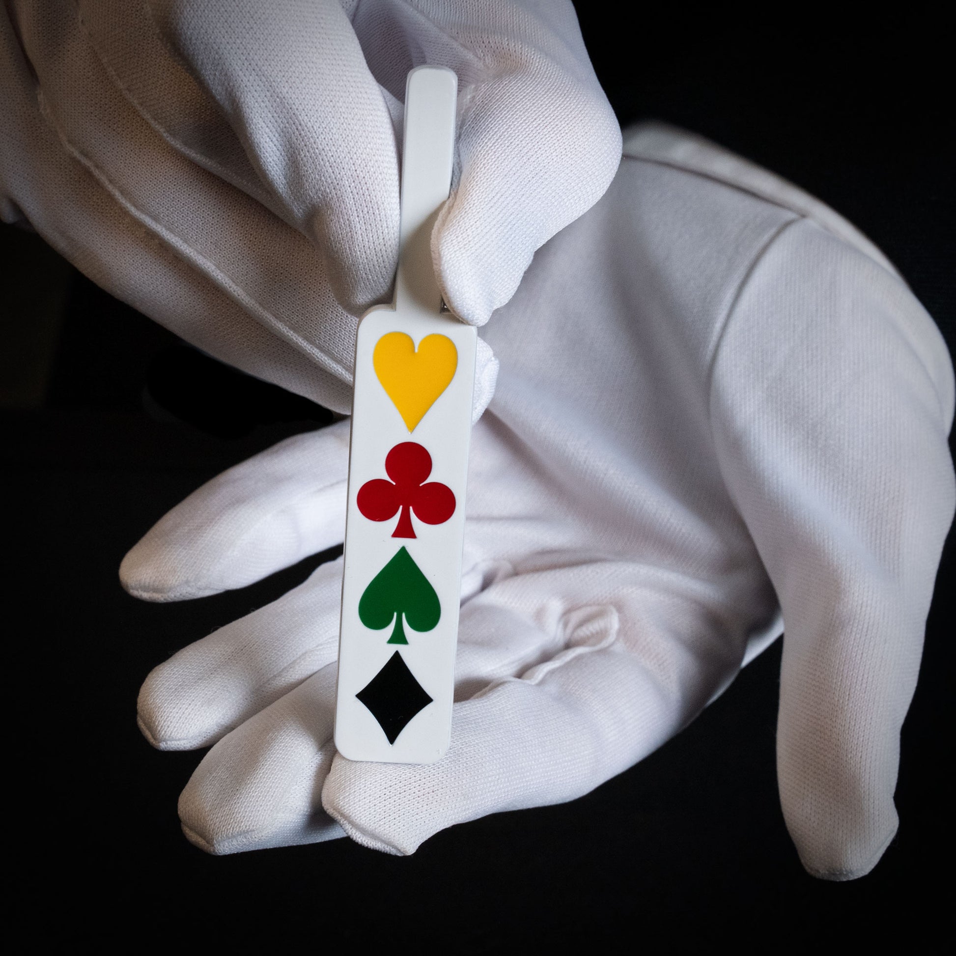 Vibrant Deception Paddle in white metal with colorful card pips, a clever magic trick tool for stunning illusions.