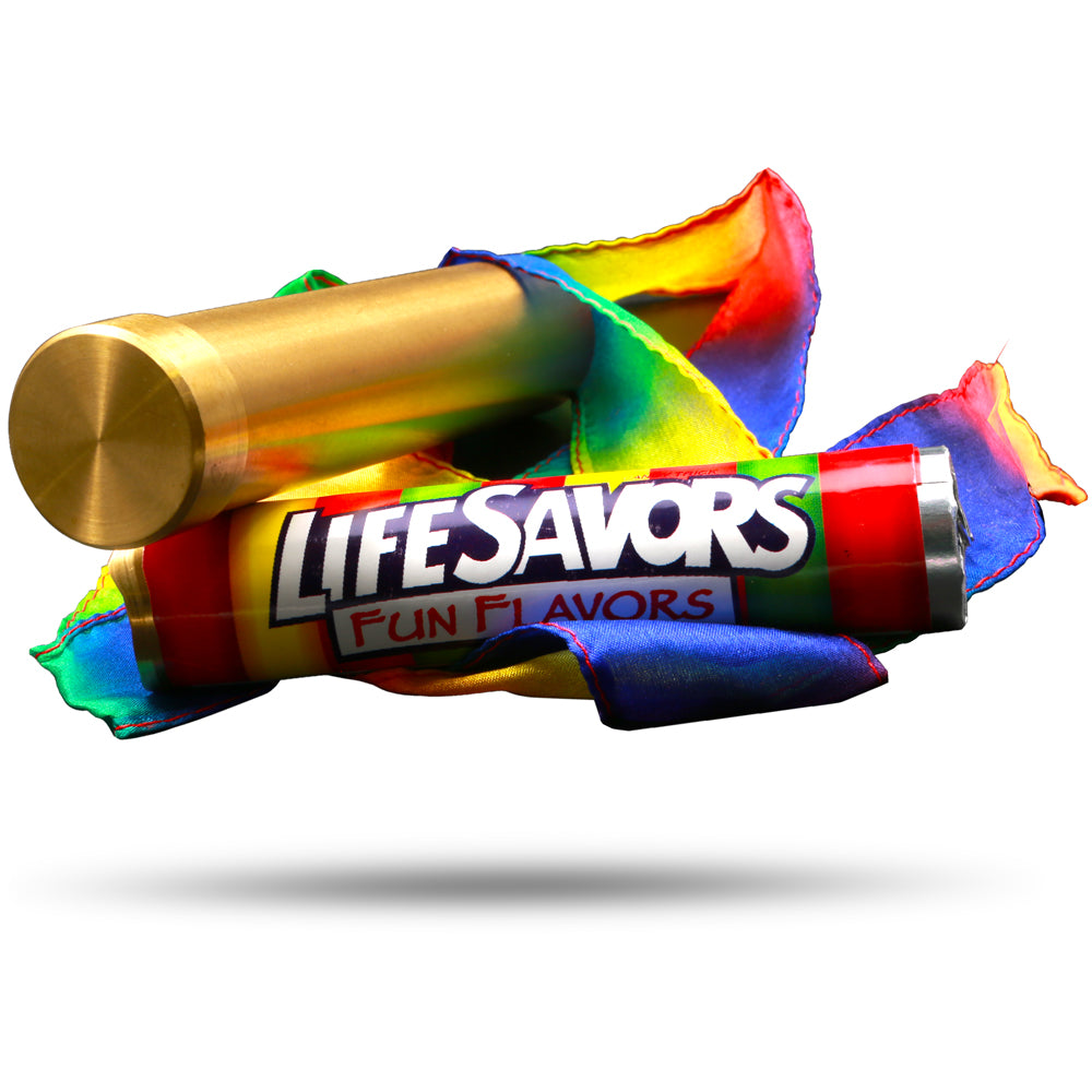 Close-up of the Vanishing Candy Illusion trick, featuring a shiny brass tube, a colorful candy roll, and a vibrant rainbow silk streamer.