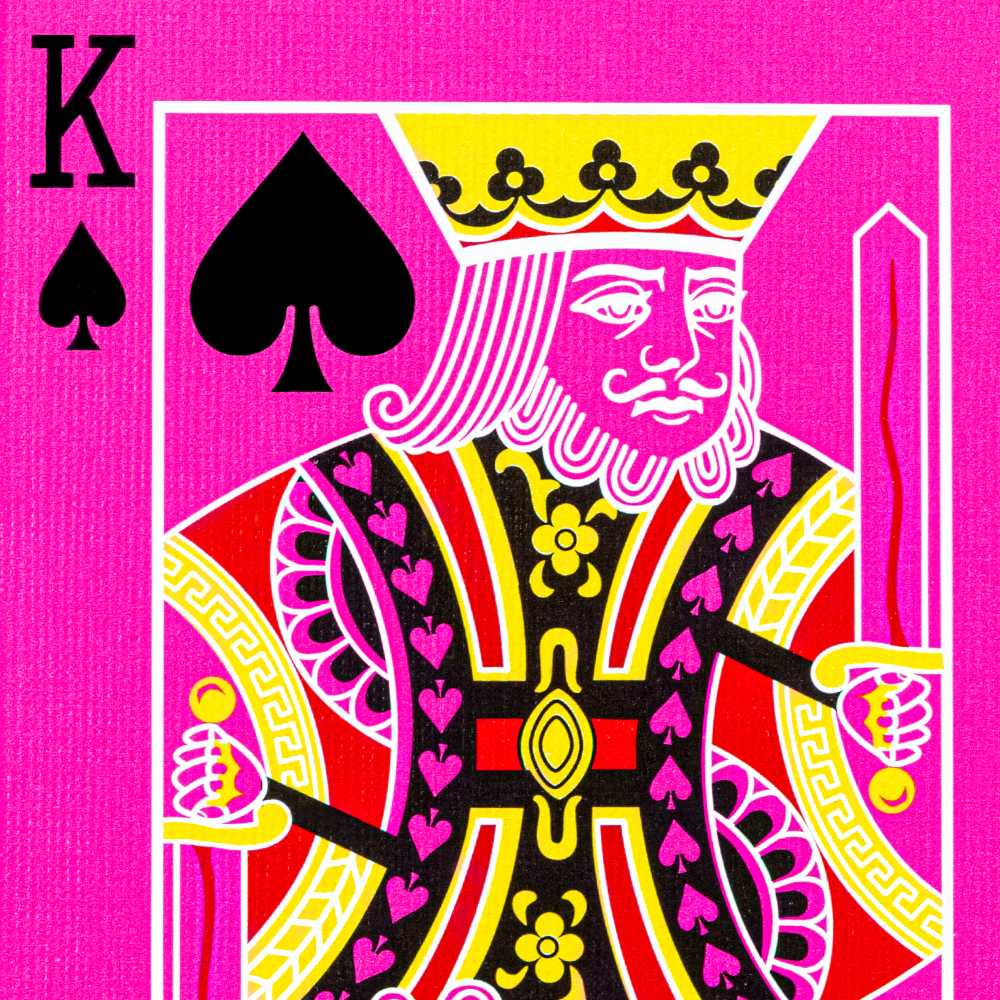 Vibrant pink Bicycle playing cards with bold black and white pips, featuring colorful court cards and extra gaff cards for tricks.