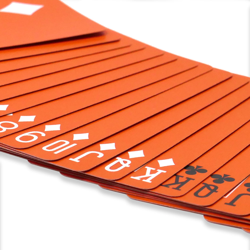 Vibrant orange Bicycle Back playing cards with a striking reversed white design, showcasing bold edges and a smooth finish.