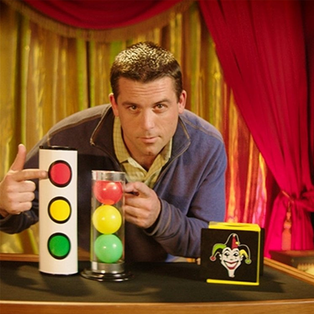 Vibrant Joker Tube set for magicians, featuring a crystal-clear tube, colorful red, yellow, and green balls, and a sturdy metal cover.