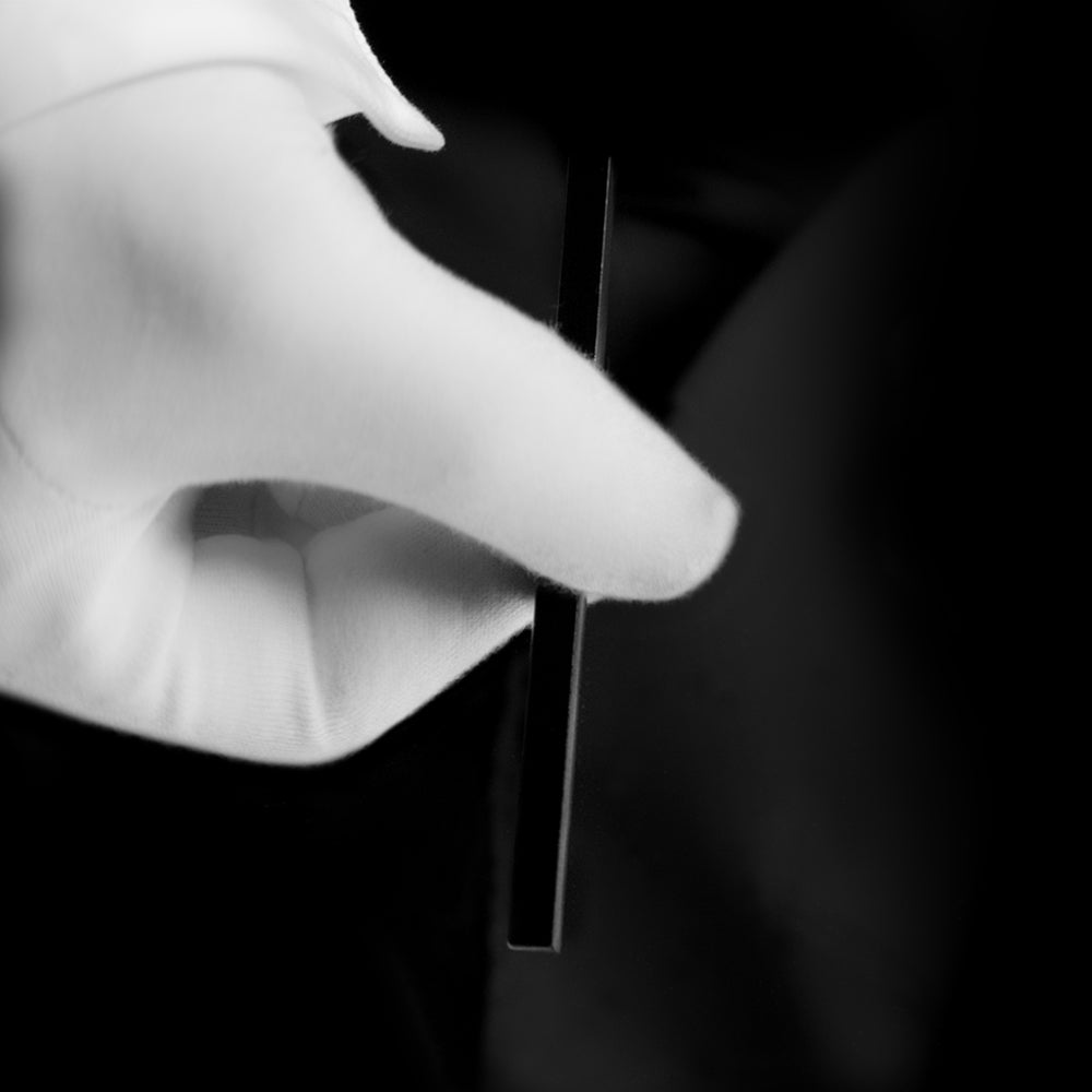 Close-up of the Magic Arrow Stick by Magic Makers, a white stick with mysterious arrows that move and vanish during the trick.