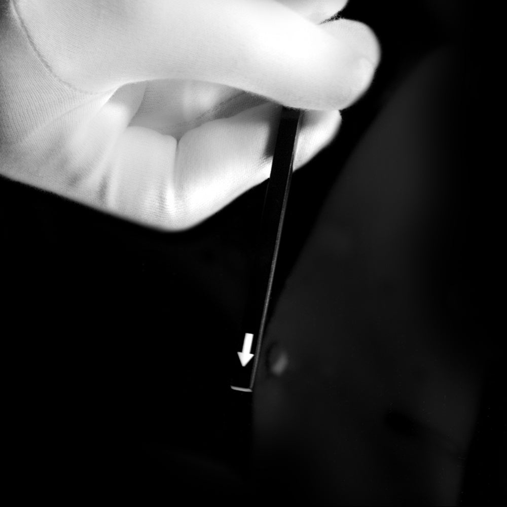 Close-up of the Magic Arrow Stick by Magic Makers, a white stick with mysterious arrows that shift and vanish during the trick.