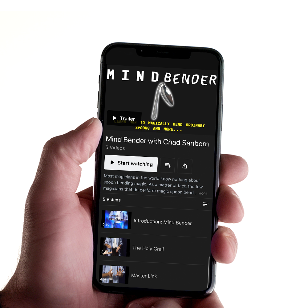 Close-up view of the Mind Bender magic kit, featuring a shiny spoon bent in an impossible curve, with coins and rubber bands nearby.