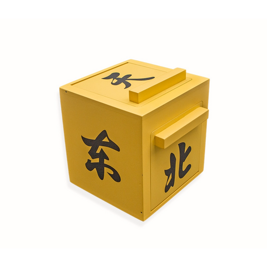 The Mandarin Mirror Box - Yellow features bold black Chinese characters on its sides and top, with rectangular handles on two sides—an eye-catching magic prop for your next illusion, set against a white background.